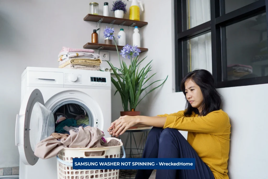disappointed Woman sitting beside her samsung washer, disappointed